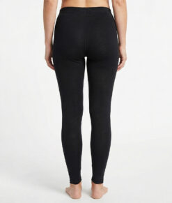 Black base layer pants. Merino Pants are made of 100% merino wool and should be worn during activities where extra warmth and good moisture transport are needed.  The image shows a female model from behind.