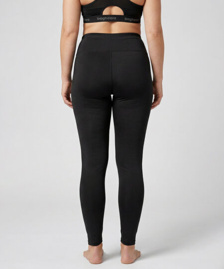 Kvinnlig modell visar ett par svarta enklare träningstights med hög midja. Modellen strår framifrån i en studio med ljusgrå bakgrund.