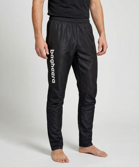 Manlig modell visar ett par svarta långa tunna orienteringsbyxor. Modellen strår framifrån i en studio med ljusgrå bakgrund.