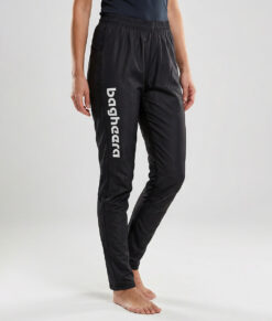 Kvinnlig modell visar ett par svarta långa tunna orienteringsbyxor. Modellen strår framifrån i en studio med ljusgrå bakgrund.