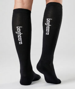 Modell visar svarta bagheera orienteringsstrumpor unisex. Modellen står bakifrån i en studio med ljusgrå bakgrund.