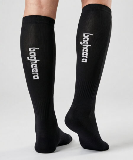 Modell visar svarta bagheera orienteringsstrumpor unisex. Modellen står bakifrån i en studio med ljusgrå bakgrund.