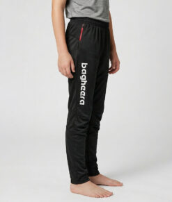 Killmodell i 12 års åldern visar ett par svarta långa tunna orienteringsbyxor. Modellen strår snett framifrån i en studio med ljusgrå bakgrund.