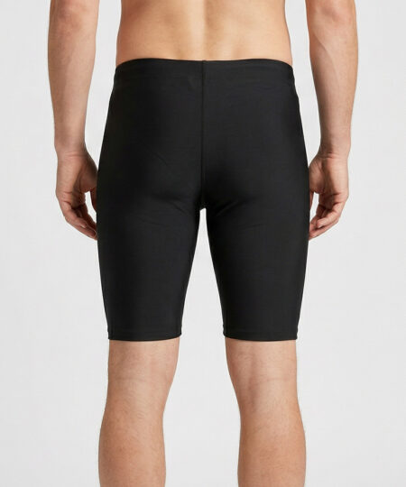 Manlig modell visar ett par svarta korta funktionstights. Modellen står bakifrån i en studio med ljusgrå bakgrund.