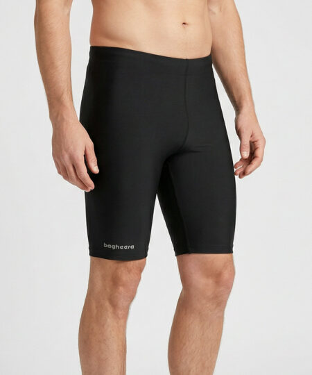 Manlig modell visar ett par svarta korta funktionstights. Modellen står snett framifrån i en studio med ljusgrå bakgrund.