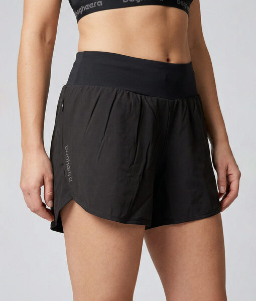 Kvinnlig modell visar ett par svarta korta tränings shorts. Modellen står snett framifrån i en studio med ljusgrå bakgrund.