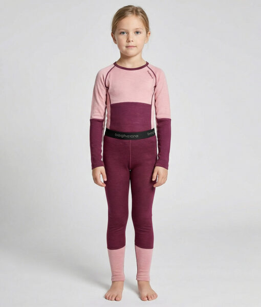 Merino Brisk är ett rosa/vinrött underställ för barn som är tillverkat i den perfekta kombinationen av material. Vi har blandat merinoull tillsammans med lyocell, som är en miljövänlig regenatfiber tillverkad av cellulosa. Bilden visar en modelltjej framifrån.