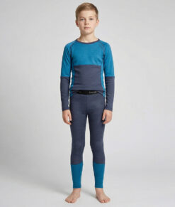 Merino Brisk är ett turkost/marinblått underställ för barn som är tillverkat i den perfekta kombinationen av material. Vi har blandat merinoull tillsammans med lyocell, som är en miljövänlig regenatfiber tillverkad av cellulosa. Bilden visar en modellkille framifrån.