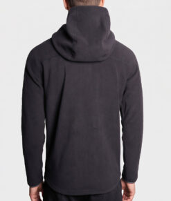 Manlig modell visar en svart långärmad lager-2 fleecejacka med huva. Modellen visar jackan bakifrån i en studio med ljusgrå bakgrund.