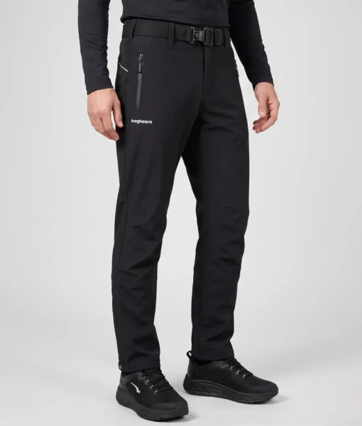 Manligmodell visar ett par svarta vinter softshell byxor. Modellen står snett framifrån i en studio med ljusgrå bakgrund.