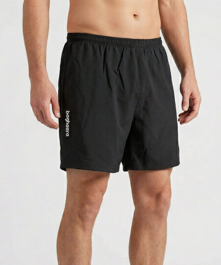 Manlig modell visar ett par svarta shorts. Modellen står snett framifrån i en studio med ljusgrå bakgrund.