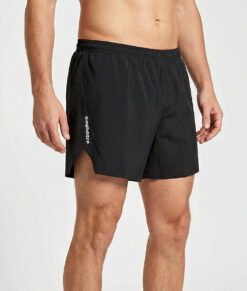 Manlig modell visar ett par svarta sprint shorts. Modellen står snett framifrån i en studio med ljusgrå bakgrund.