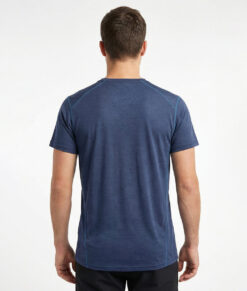 Merino Brisk är en marinblå t-shirt tillverkad i den perfekta kombinationen av material. Vi har blandat merinoull tillsammans med lyocell, som är en miljövänlig regenatfiber tillverkad av cellulosa. Bilden visar en manlig modell bakifrån.