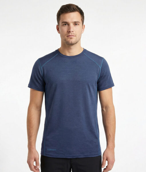 Merino Brisk är en marinblå t-shirt tillverkad i den perfekta kombinationen av material. Vi har blandat merinoull tillsammans med lyocell, som är en miljövänlig regenatfiber tillverkad av cellulosa. Bilden visar en manlig modell framifrån.