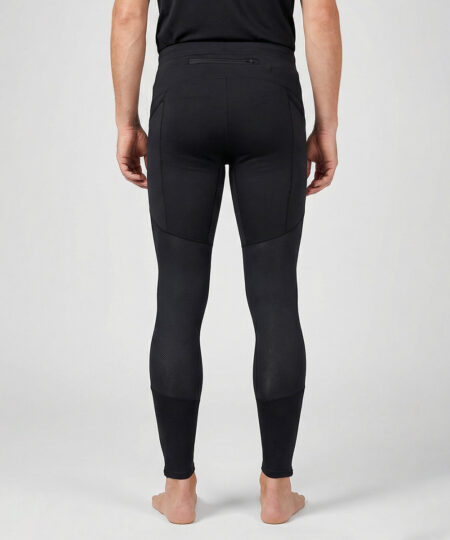 Manlig modell visar ett par svarta långa tights. Modellen står bakifrån i en studio med ljusgrå bakgrund.