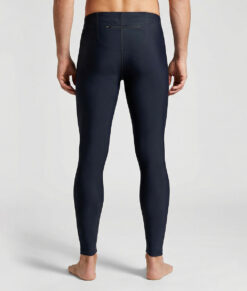 Manlig modell visar ett par svarta långa tights. Modellen står bakifrån i en studio med ljusgrå bakgrund.