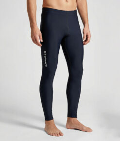 Manlig modell visar ett par svarta långa tights. Modellen står framifrån i en studio med ljusgrå bakgrund.