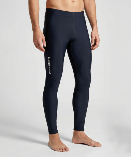 Manlig modell visar ett par svarta långa tights. Modellen står framifrån i en studio med ljusgrå bakgrund.