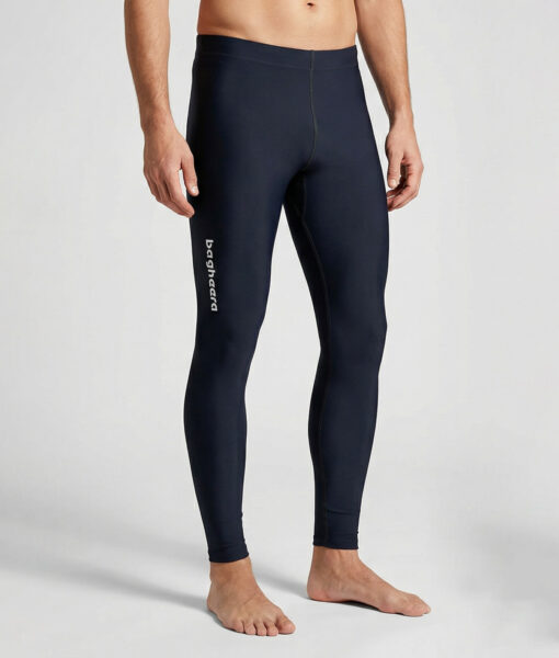 Manlig modell visar ett par svarta långa tights. Modellen står framifrån i en studio med ljusgrå bakgrund.