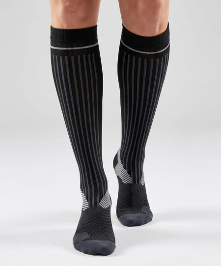 Modell visar ett par svarta bagheera kompressions-strumpor. Modellen står framifrån i en studio med ljusgrå bakgrund.