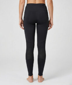 Kvinnlig modell visar ett par svarta slitstark trail tights. Modellen står bakifrån i en studio med ljusgrå bakgrund.