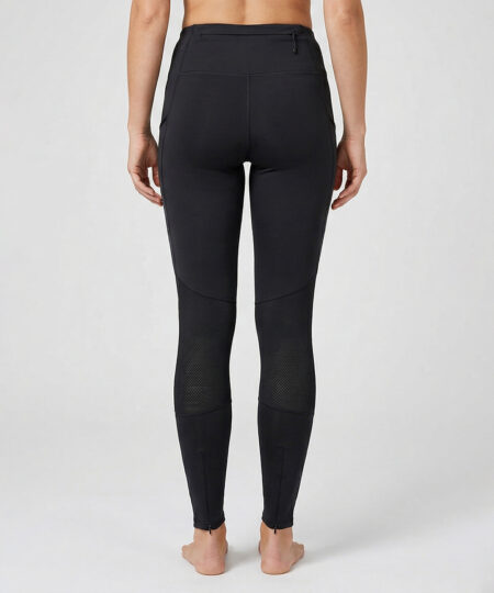 Kvinnlig modell visar ett par svarta slitstark trail tights. Modellen står bakifrån i en studio med ljusgrå bakgrund.