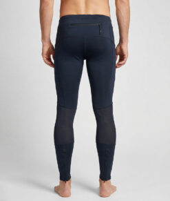 Manlig modell visar ett par svarta slitstark trail tights. Modellen står bakifrån i en studio med ljusgrå bakgrund.