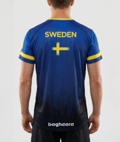 Manlig modell visar en blå luftig orienterings t-shirt för herr. Svenska flaggan. Modellen står bakifrån i en studio med ljusgrå bakgrund.