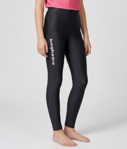 En tjejmodell i 12 års åldern visar ett par svarta enklare långa tights. Modellen står framifrån i en studio med ljusgrå bakgrund.