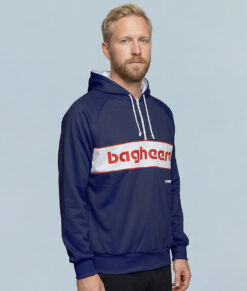 Manlig modell visar en marinblå klassisk bagheera montana wct hoodie herr. Modellen står snett framifrån i en studio med ljusblå bakgrund.