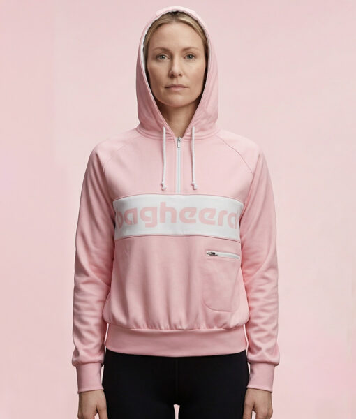 Kvinlig modell visar en rosa klassisk bagheera montana wct hoodie för dam. Modellen står framifrån med huvan på i en studio med ljusrosa bakgrund.
