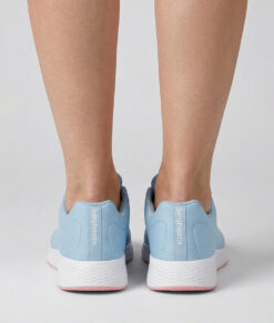 Kvinlig modell visar en ljusblå bagheera vision sneaker. Modellen står bakifrån i en studio med ljusgrå bakgrund.