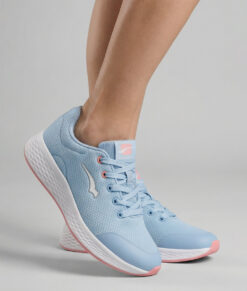 Kvinlig modell visar en ljusblå bagheera vision sneaker. Modellen står snett framifrån i en studio med ljusgrå bakgrund.