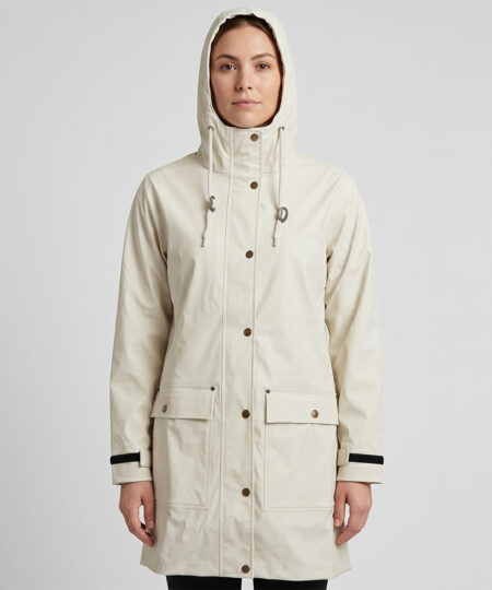Kvinlig modell visar en naturvit klassisk regnjacka. Modellen har huvan uppfälld och står framifrån i en studio med ljusgrå bakgrund.