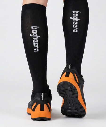 Modell visar svarta orangefärgade bagheera feral r1 orienterings-skor. Modellen står bakifrån i en studio med ljusgrå bakgrund.