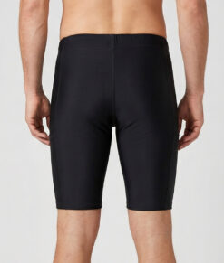 Manlig modell visar ett par svarta korta tights. Modellen står framifrån i en studio med ljusgrå bakgrund.