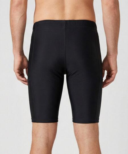 Manlig modell visar ett par svarta korta tights. Modellen står framifrån i en studio med ljusgrå bakgrund.