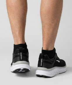 Manlig modell visar ett par svarta bagheera prime löparskor. Modellen står bakifrån i en studio med ljusgrå bakgrund.