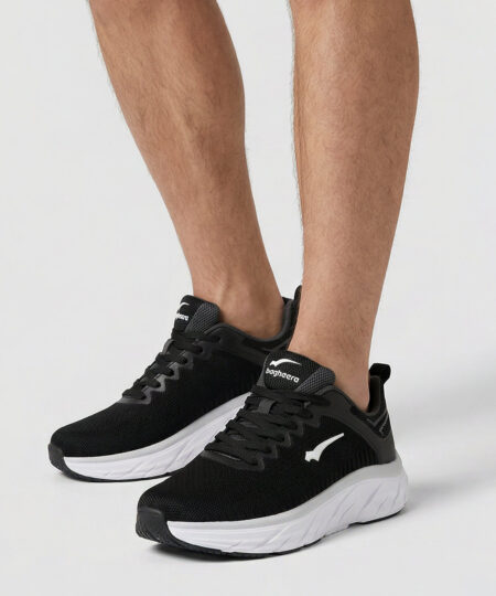 Manlig modell visar ett par svarta bagheera prime löparskor. Modellen står snett framifrån i en studio med ljusgrå bakgrund.