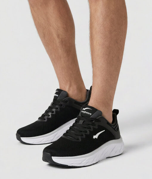 Manlig modell visar ett par svarta bagheera prime löparskor. Modellen står snett framifrån i en studio med ljusgrå bakgrund.