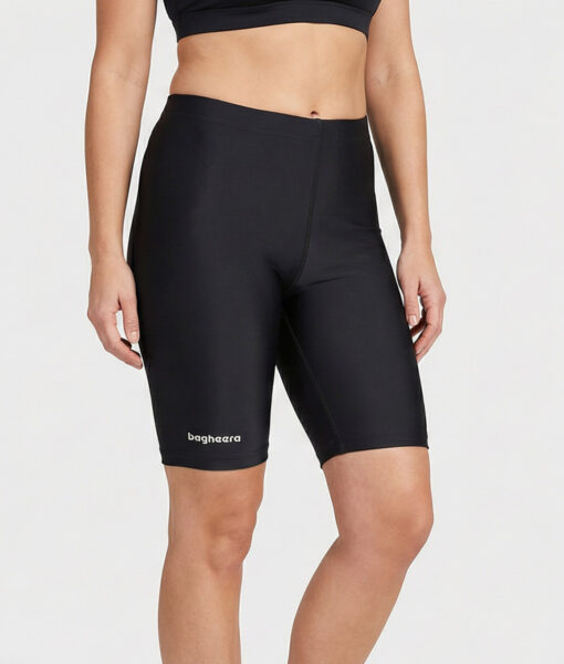 Kvinnlig modell visar ett par svarta korta tränings tights. Modellen står framifrån i en studio med ljusgrå bakgrund.