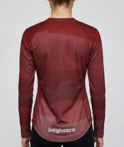 Kvinlig modell visar en vinröd långärmad orienteringströja för dam. Modellen står bakifrån i en studio med ljusgrå bakgrund.