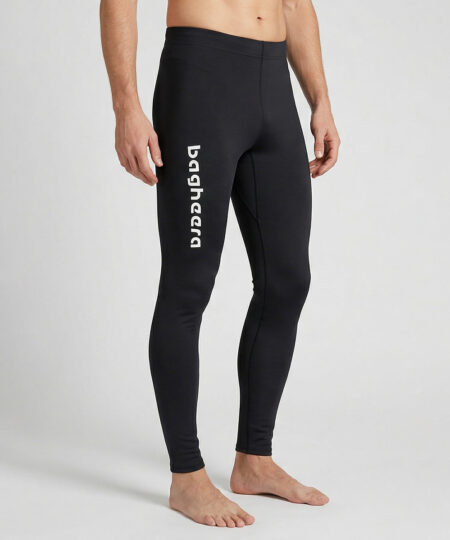 Manlig modell visar ett par svarta långa tights. Modellen står framifrån i en studio med ljusgrå bakgrund.