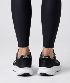 Kvinlig modell visar en svart bagheera octane sneaker. Modellen står bakifrån i en studio med ljusgrå bakgrund.