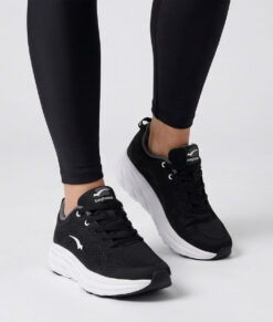 Kvinlig modell visar en svart bagheera octane svart sneaker. Modellen står framifrån i en studio med ljusgrå bakgrund.