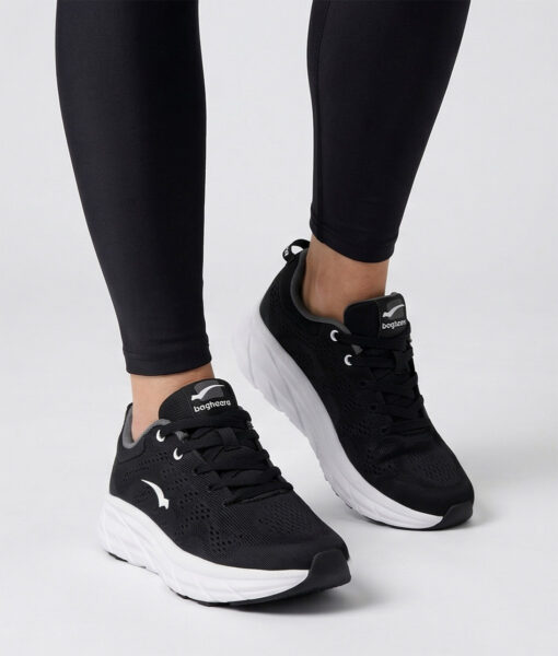 Kvinlig modell visar en svart bagheera octane svart sneaker. Modellen står framifrån i en studio med ljusgrå bakgrund.