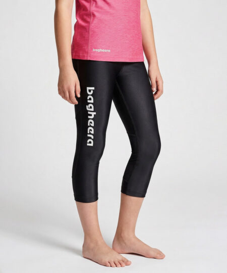 En tjejmodell på 12 år visar ett par svarta 3/4 långa race tights. Modellen står framifrån i en studio med ljusgrå bakgrund.