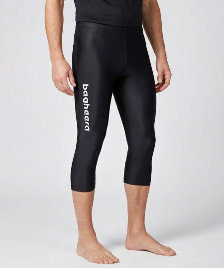 Manlig modell visar ett par svarta trekvarts långa race tights. Modellen står framifrån i en studio med ljusgrå bakgrund.