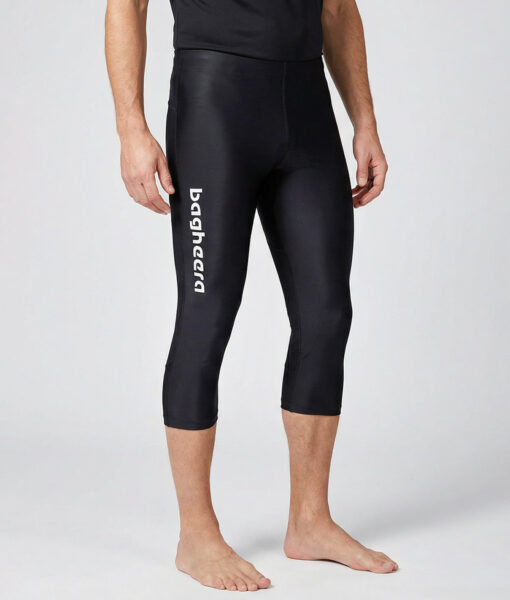 Manlig modell visar ett par svarta trekvarts långa race tights. Modellen står framifrån i en studio med ljusgrå bakgrund.