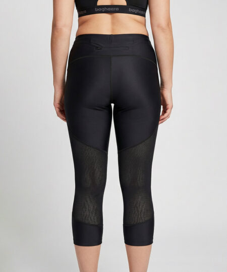 Kvinnlig modell visar ett par svarta 3/4 långa race tights. Modellen står bakifrån i en studio med ljusgrå bakgrund.